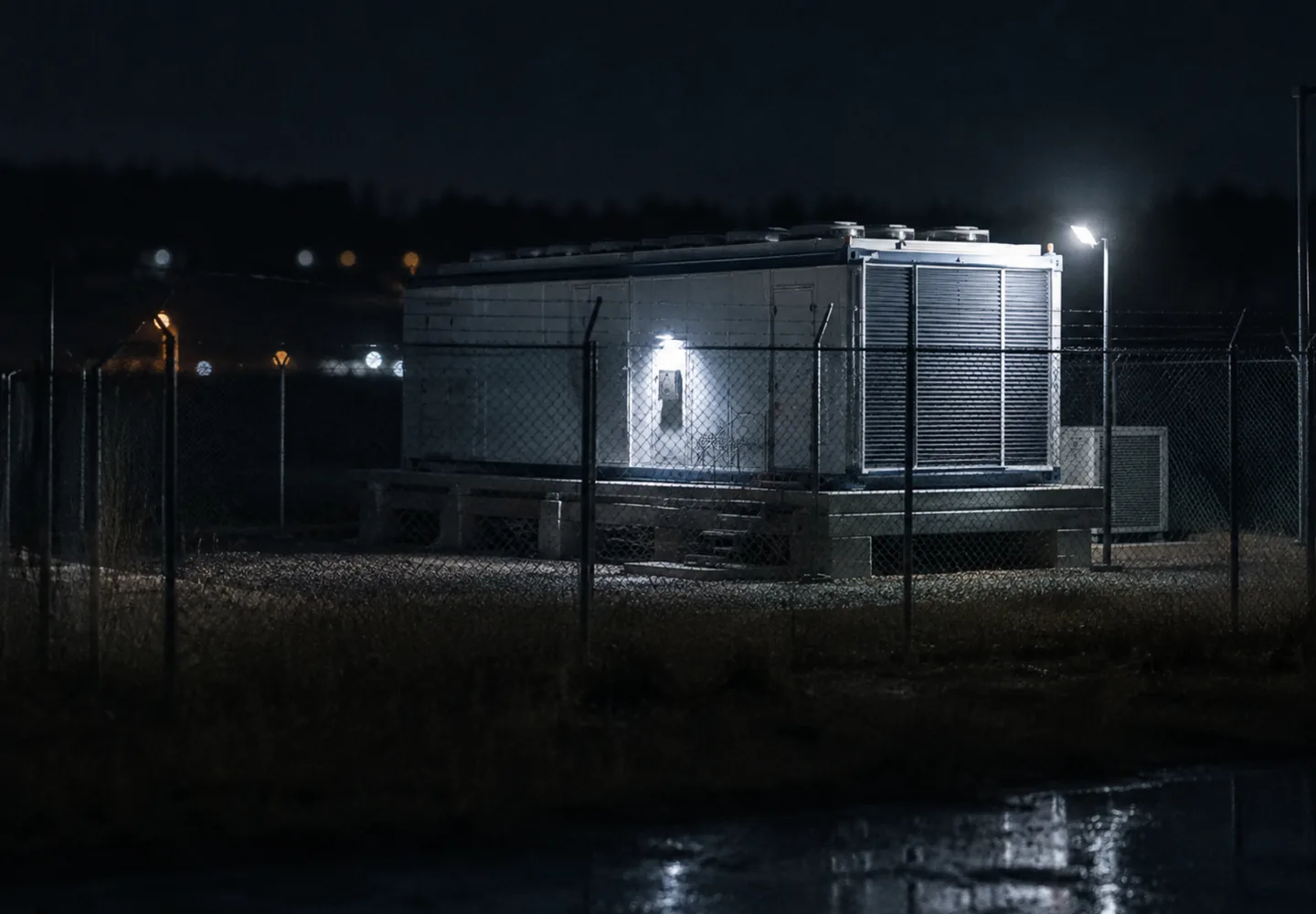 A CGiX unit lit behind a security fence at night